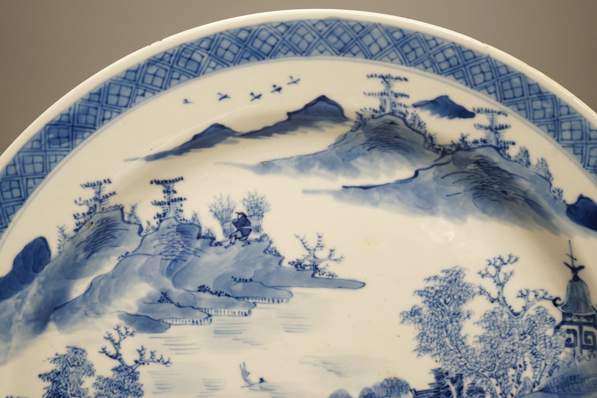 A Chinese blue and white landscape dish, Kangxi mark but 19th century, 36cm